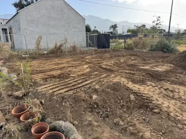Site preparation with heavy machinery tire tracks and stucco building under construction
