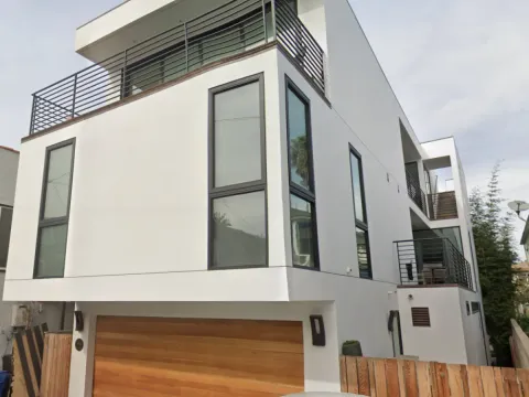 18th Street - Completed 3-story white stucco residence in Hermosa Beach with cantilevered facade